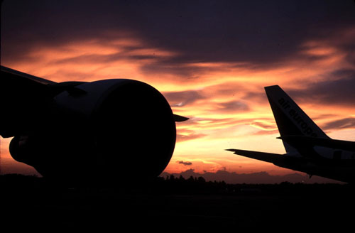 Magnifico tramonto tra due aerei wide-body parcheggiati all'aeroporto di Milano Malpensa